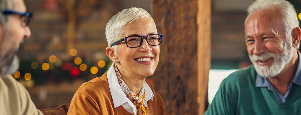 Image of senior woman talking and laughing with 2 senior men